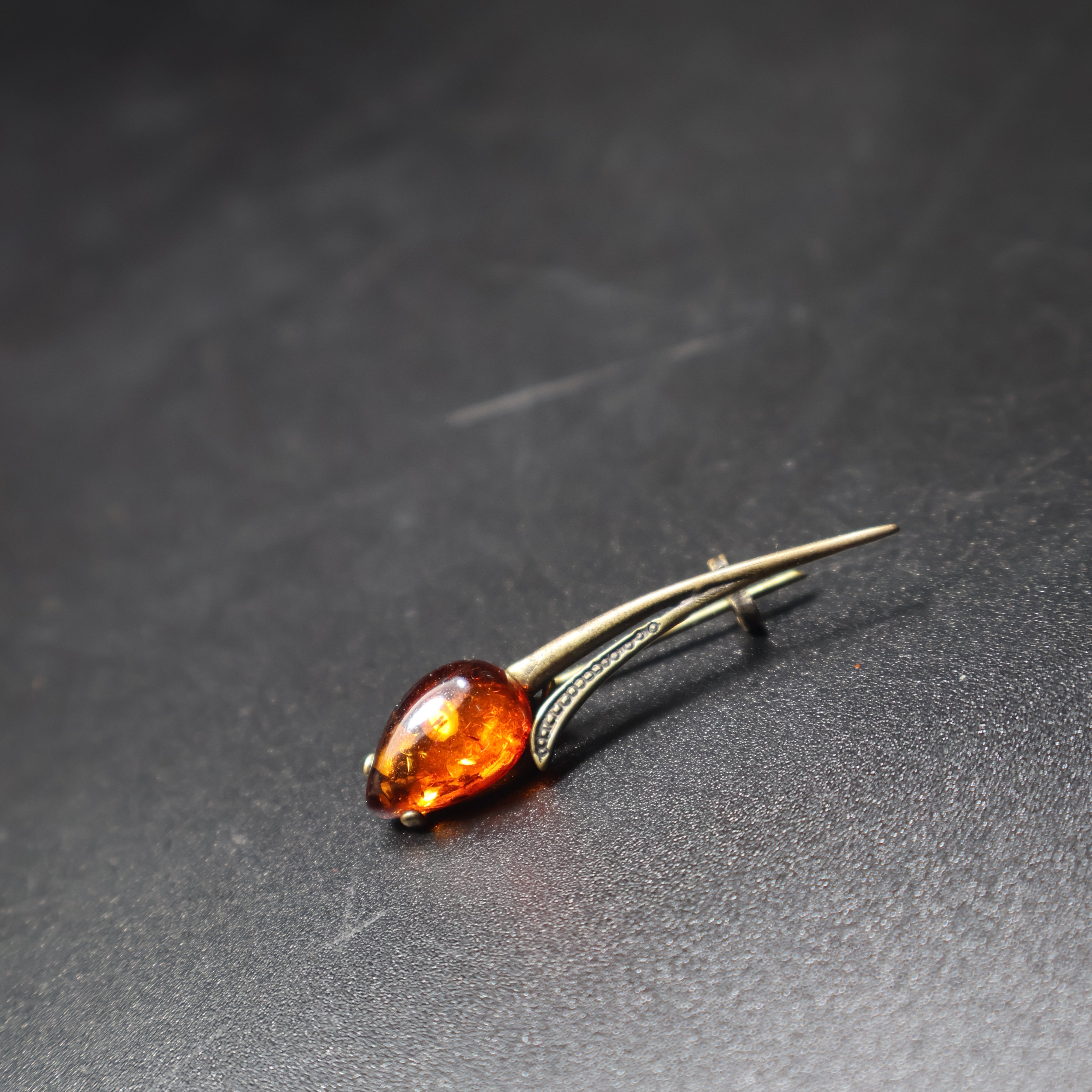 Handmade Baltic amber tulip brooch close-up showing natural stone