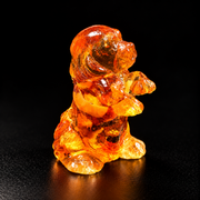 Made in USA natural Baltic amber begging puppy figurine, puppy sitting up on hind legs with paws raised glowing honey-cognac on black studio background — KIZIMA® Brooklyn NY