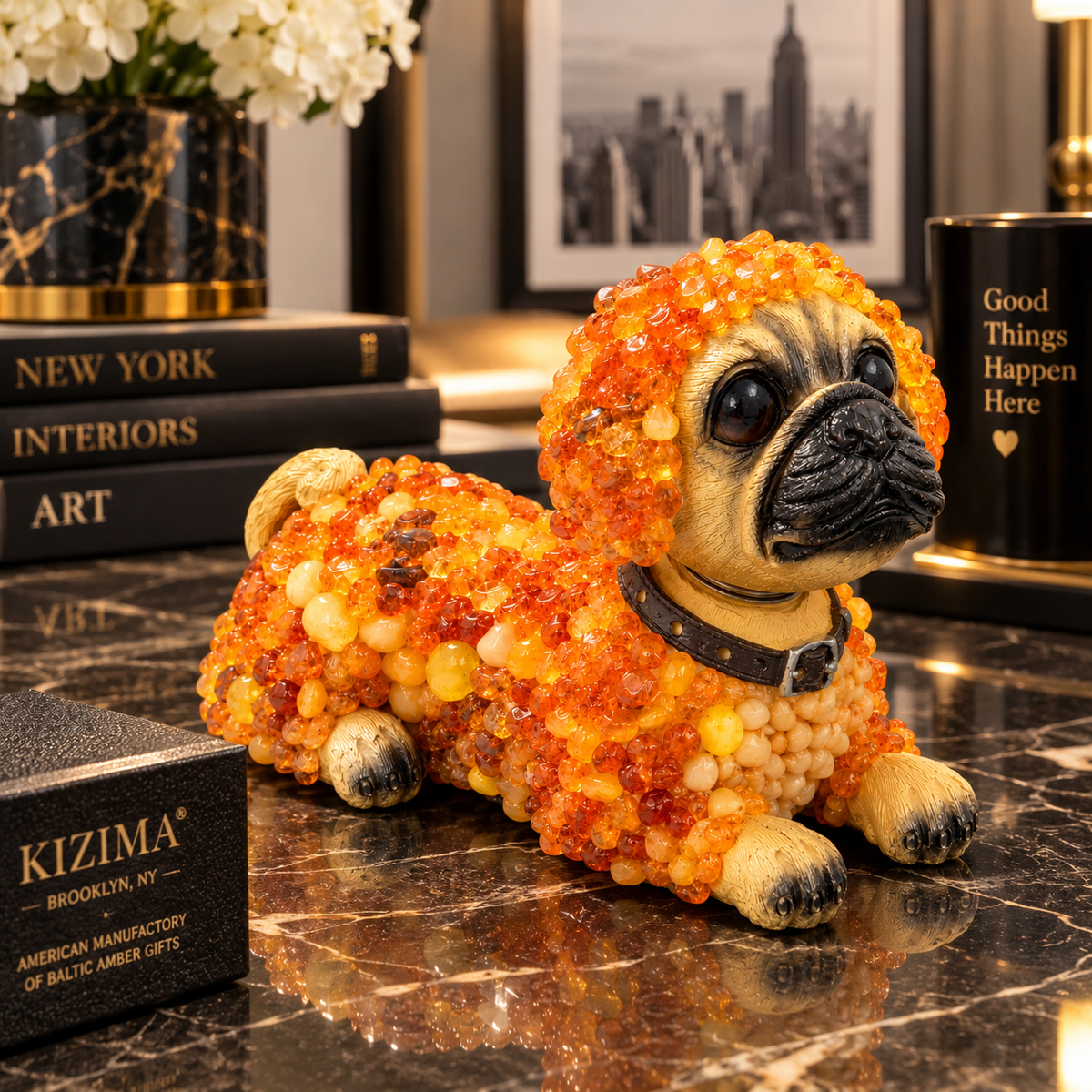 Made in USA natural Baltic amber bobblehead pug figurine on a marble console with KIZIMA® gift box in a Manhattan living room — pug lover gift