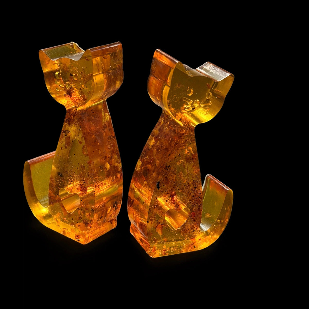 Back view of the amber cat couple figurines on black background, handcrafted in Brooklyn from natural Baltic amber