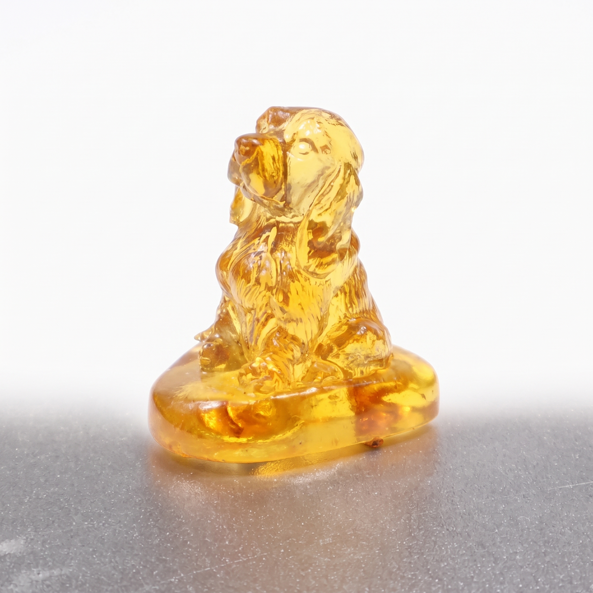 Made in USA natural Baltic amber Cocker Spaniel figurine on pure white background — sitting spaniel on amber base, KIZIMA® Brooklyn NY
