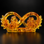 Made in USA Natural Baltic Amber infinity love sculpture by KIZIMA® on a black studio backdrop, bride and groom and grandparents