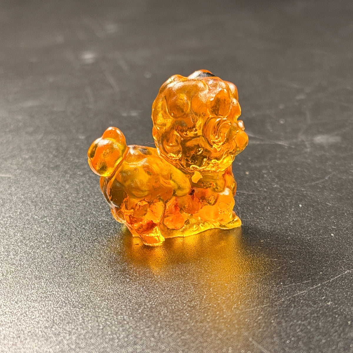 Honey-tone Baltic amber mini sheep glowing in the light, reverse side view, Lunar New Year 2027 gift Made in USA by KIZIMA®