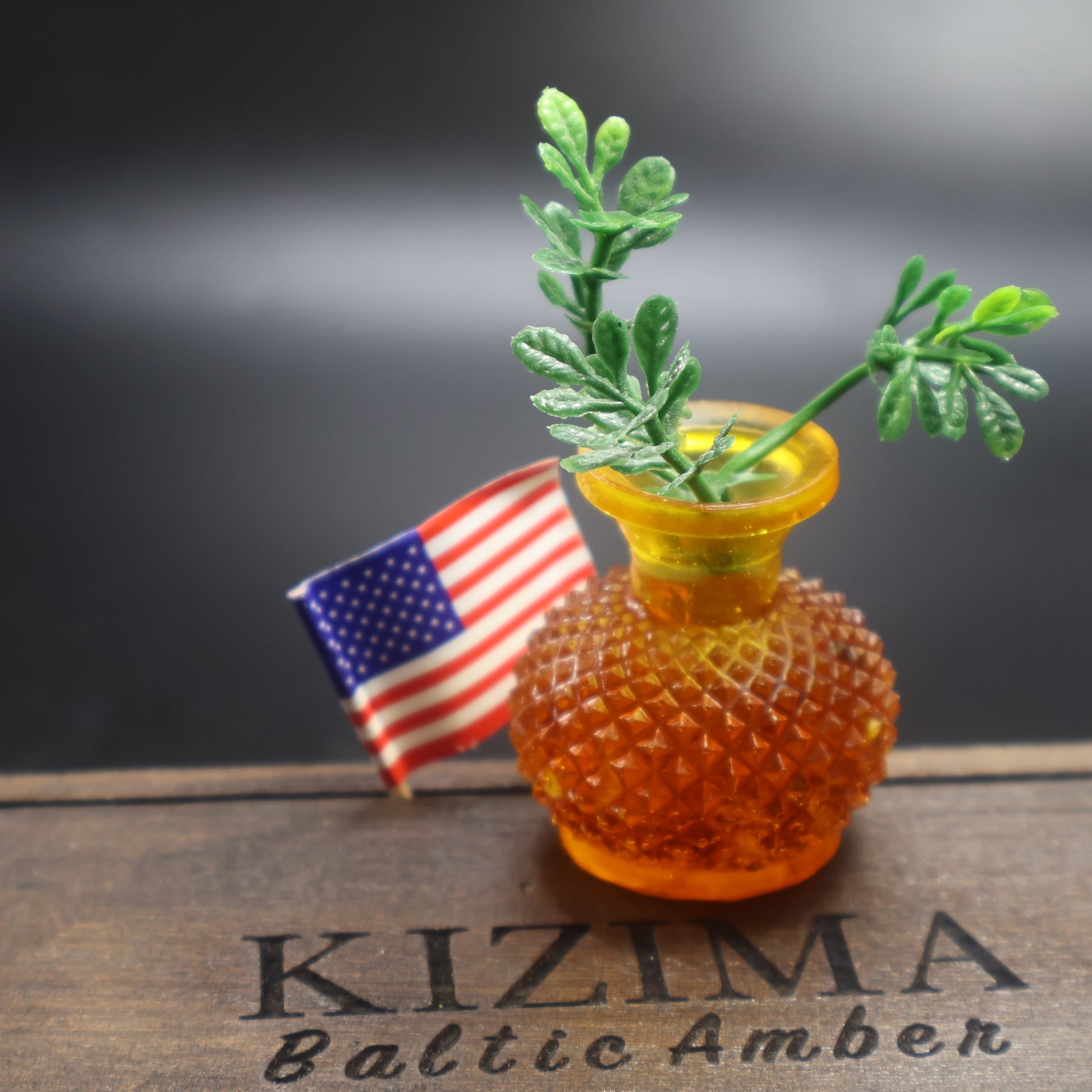 Handcrafted Baltic amber miniature vase beside US flag on KIZIMA® Baltic Amber gift box, made in Brooklyn NY