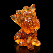 Made in USA natural Baltic amber mini Yorkie figurine, sitting Yorkshire Terrier puppy glowing honey-cognac on black studio background, handcrafted by KIZIMA® Brooklyn NY