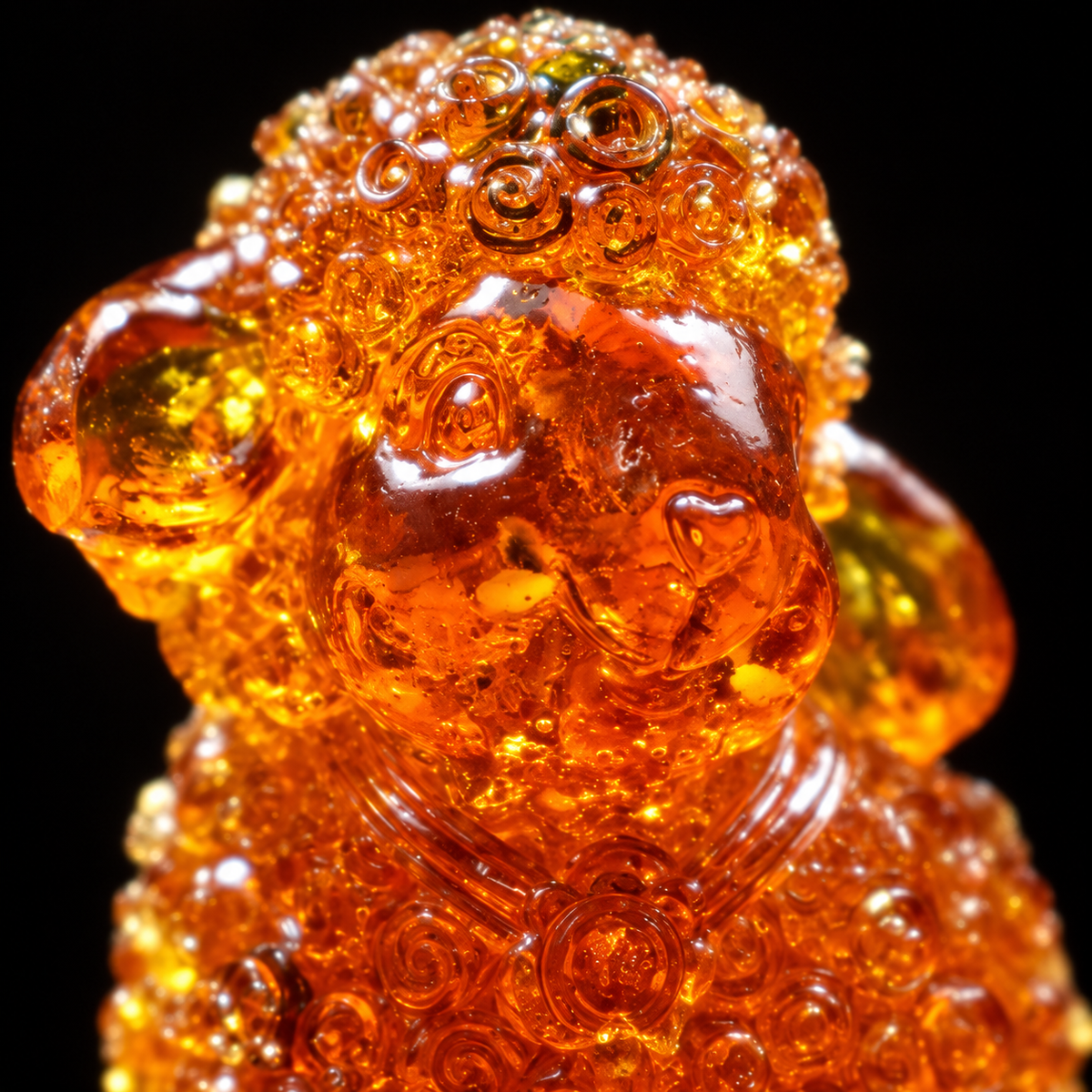 Macro detail of the lamb's face and curled fleece in genuine Baltic amber, Made in USA nativity keepsake by KIZIMA®