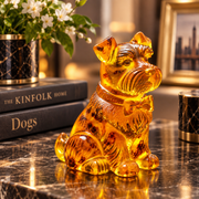 Made in USA natural Baltic amber Miniature Schnauzer dog figurine by KIZIMA® on a marble desk with books and flowers — honey amber with bow collar, dog lover gift
