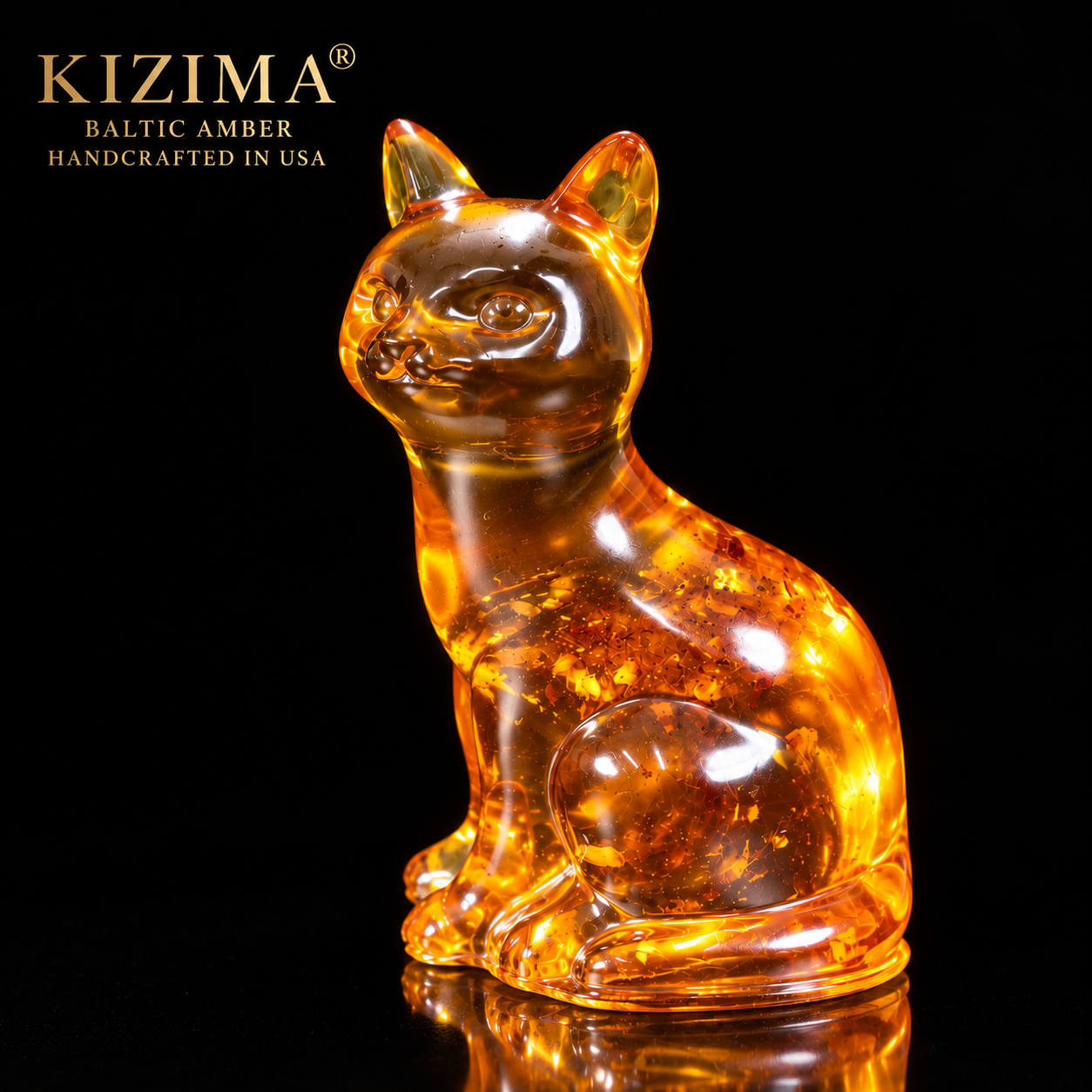 Made in USA natural Baltic amber sitting cat figurine by KIZIMA®, cognac amber with golden inclusions on black studio background