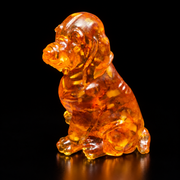 Left-facing three-quarter view of a seated amber spaniel, with smooth drooping ears and a rounded muzzle against black.