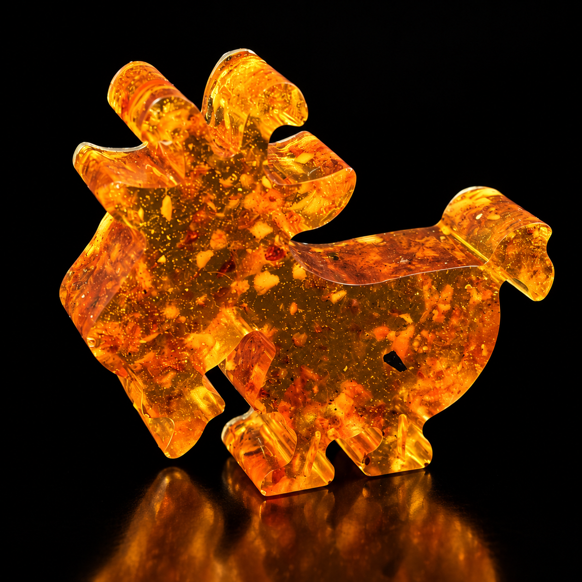 Small Made in USA Natural Baltic Amber Yule goat figurine by KIZIMA® on a black studio backdrop, Christmas stocking stuffer