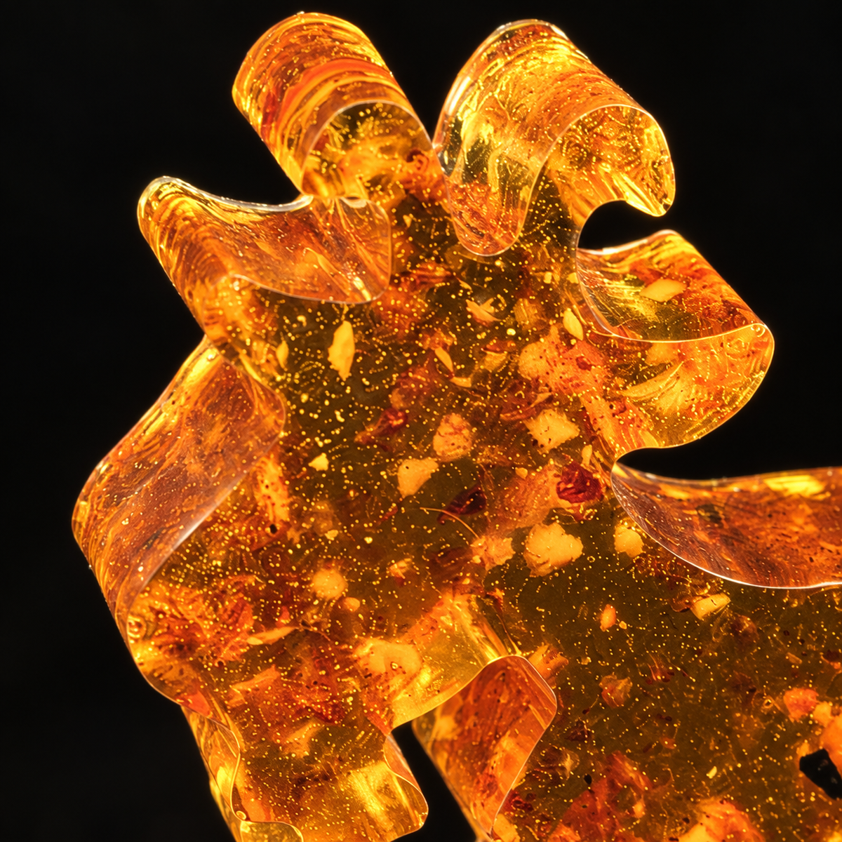 Macro detail of the small amber Yule goat's face, light through genuine Baltic amber, Made in USA by KIZIMA®