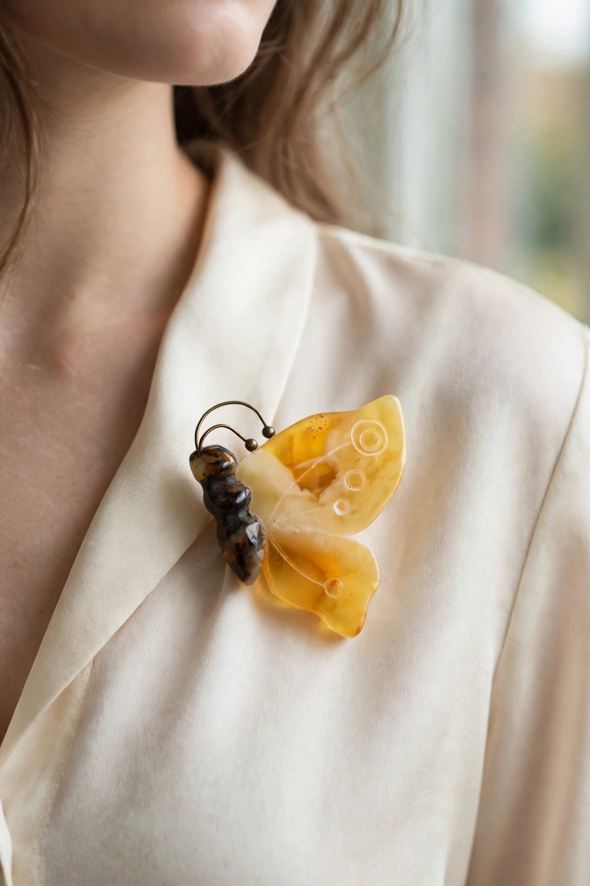 Handmade Baltic amber butterfly brooch worn on a model — KIZIMA, Made in USA
