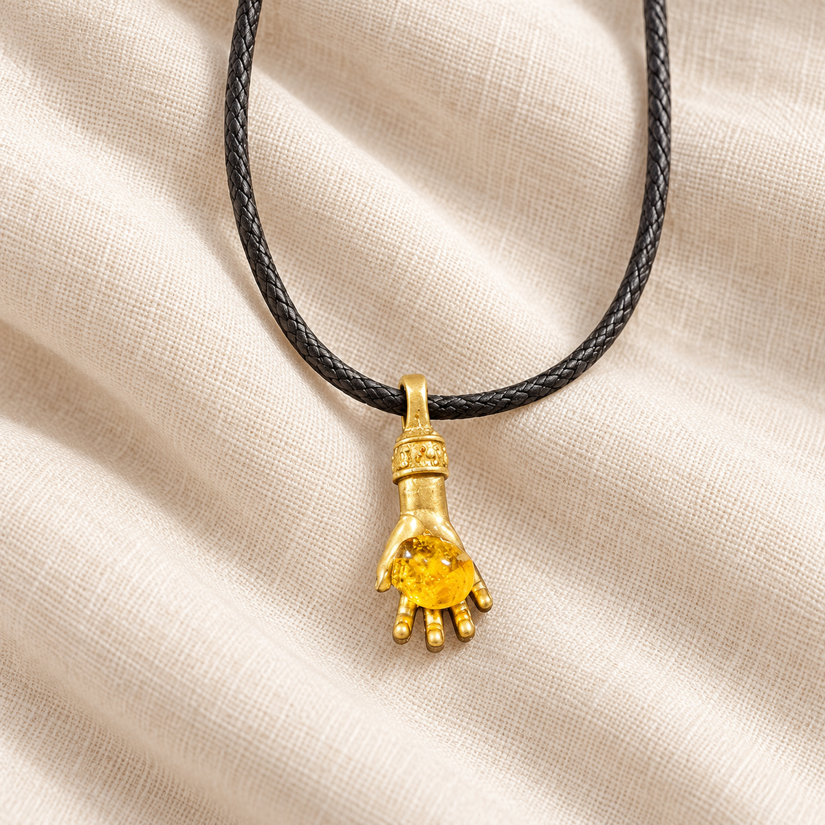 Made in USA Natural Baltic Amber money hand pendant on cord by KIZIMA® resting on light fabric