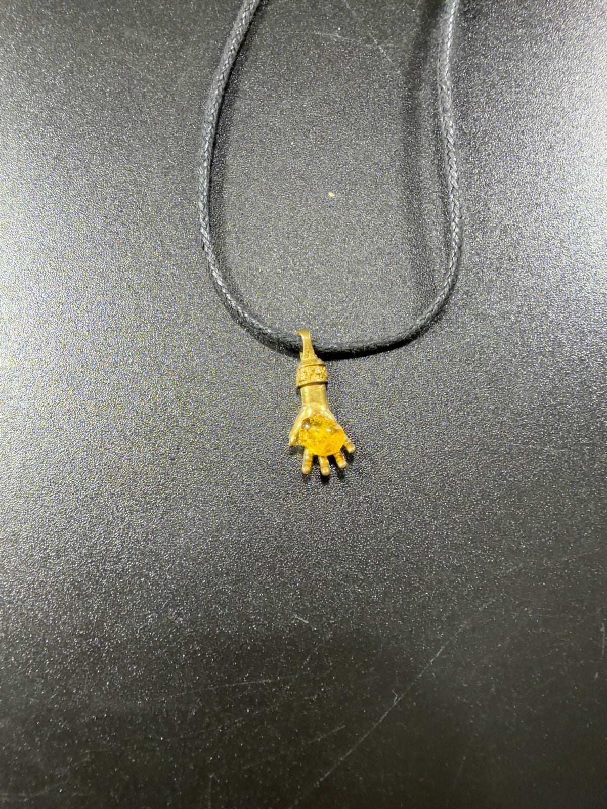 Made in USA Natural Baltic Amber money hand pendant on a dark cord by KIZIMA®, original product photo