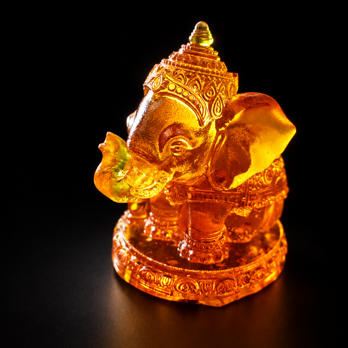 Natural Baltic amber Ganesha statue with ornate crown and raised trunk, three-quarter view on a black background.