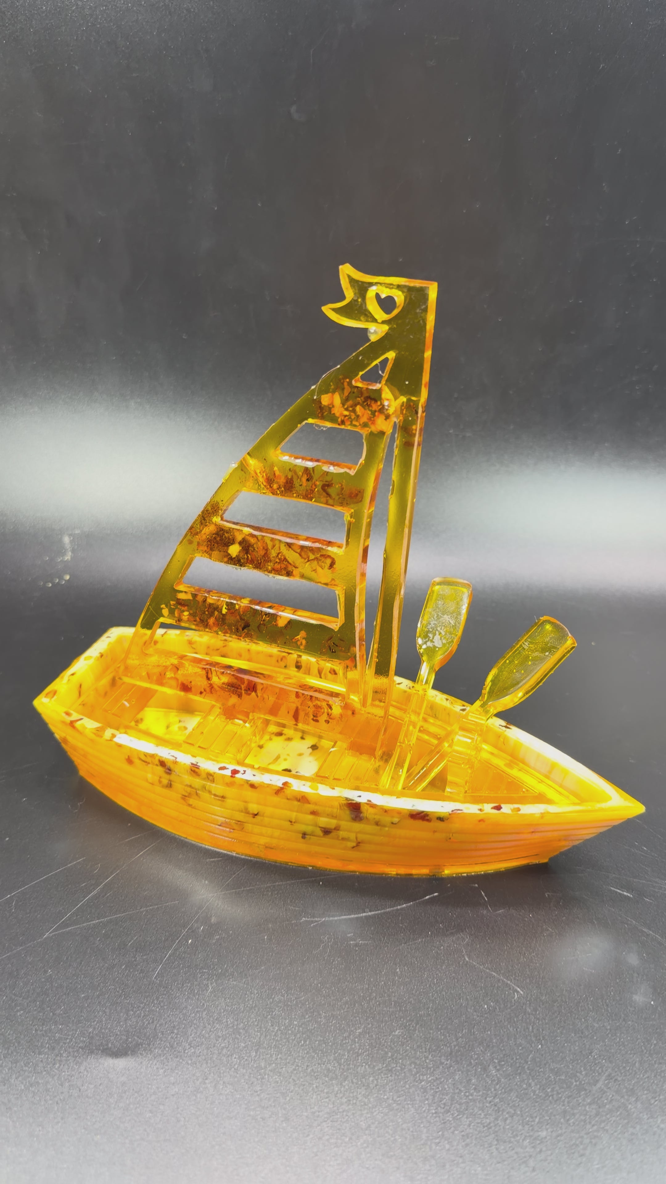 Load video: KIZIMA Baltic amber sailboat sculpture, handmade in USA, rotating video